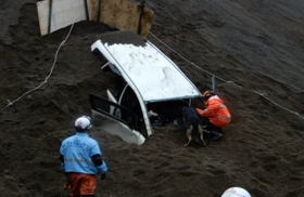 土砂とともに崖下に落下した車両内にいる要救助者を、消防と救助犬が捜索し、救助しました写真