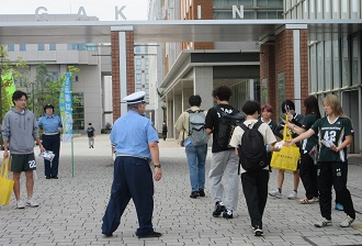 関東学院大学正門で啓発物品を配布している