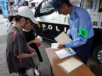 親子に警察からのお知らせを伝える警察官