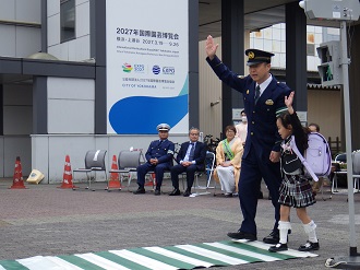 横断歩道通行の実演を行う瀬谷警察署長と新一年生の児童